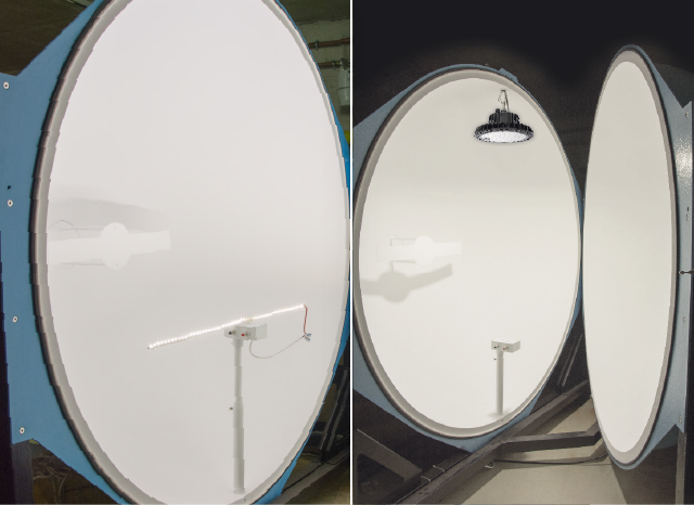 Due grandi sfere bianche e circolari (sfere di Ulbricht) si trovano in una stanza. Una &egrave; posizionata direttamente davanti all&rsquo;altra, montata sulla parete. Una lampada a soffitto &egrave; sospesa sopra.