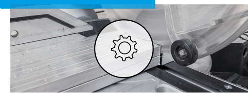 Une scie circulaire découpe avec précision un profilé en aluminium. Une icône transparente en forme d’engrenage est superposée au premier plan.