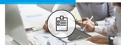 Plusieurs mains travaillent avec une tablette et des documents sur un bureau dans un bureau ; une icône circulaire avec un presse-papiers est superposée.